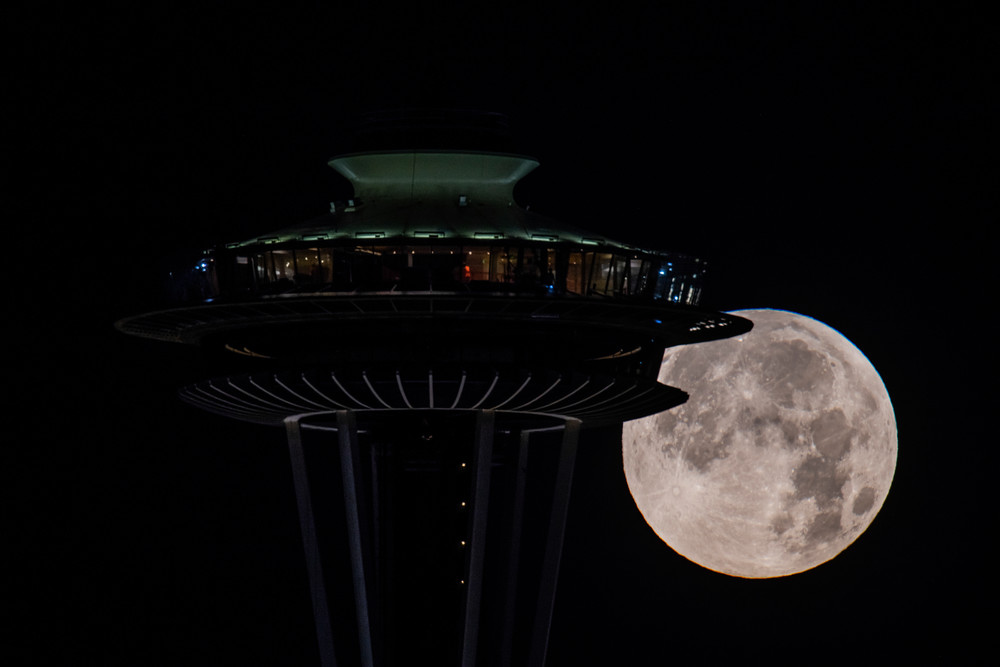 Full moon setting behind Space Needle