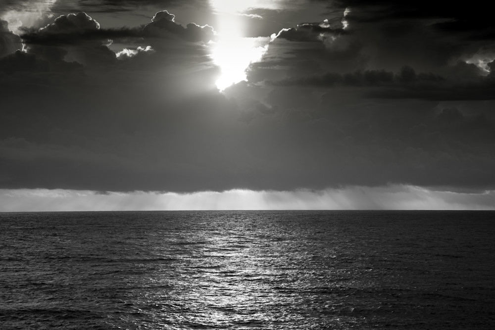 The sunsets on the ocean, while a storm brews in the distance. This photograph can be enlarged to any size and can be a reminder in your home office of the wonders of nature.