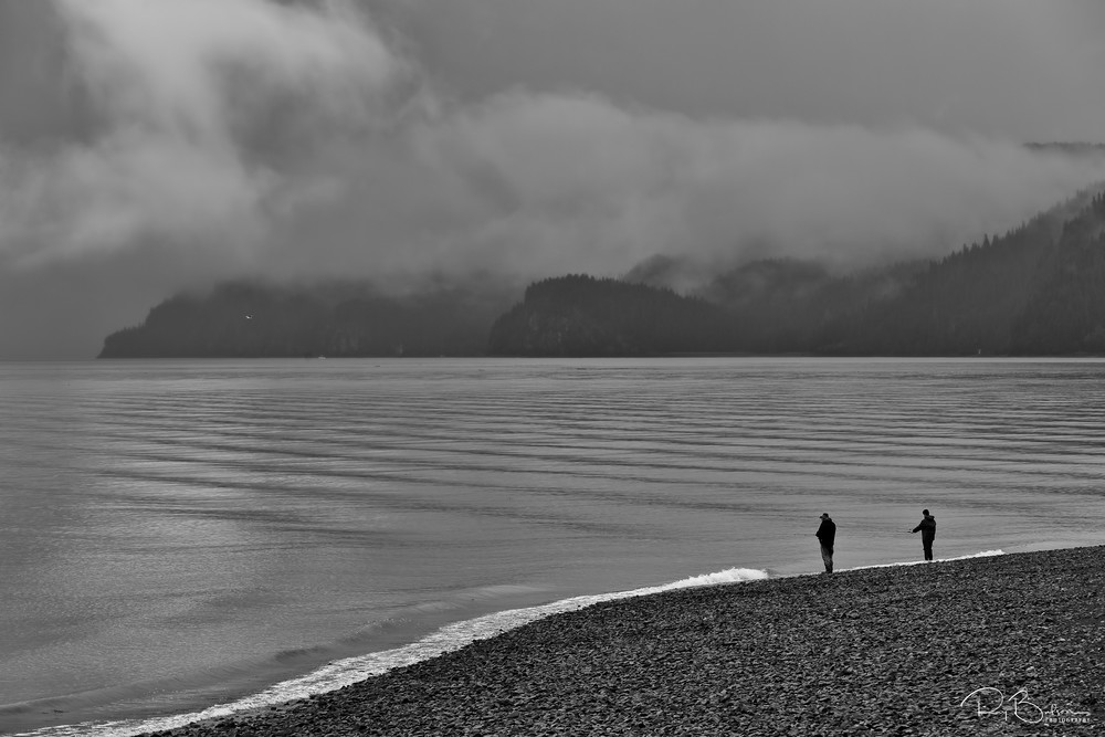 Two fisherman fishing for salmon in Resurrection Bay along Lowell Point in Seward in morning fog on the Kenai Peninsula in Southcentral Alaska. Summer.