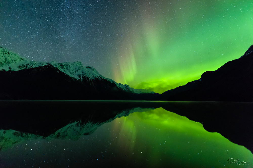 The aurora borealis is reflected in Chilkoot Lake near Haines in Southeast Alaska. Winter. Evening.