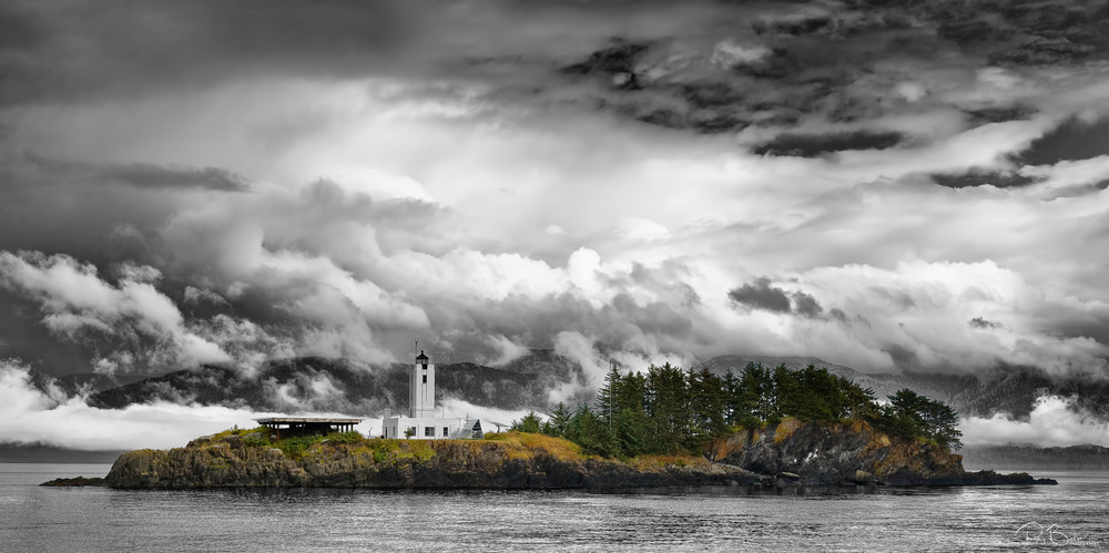 Fog and clouds highlight the need for The Five Finger Lighthouse in Stephens Passage in the Inside Passage of Southeast Alaska. Summer. Afternoon.