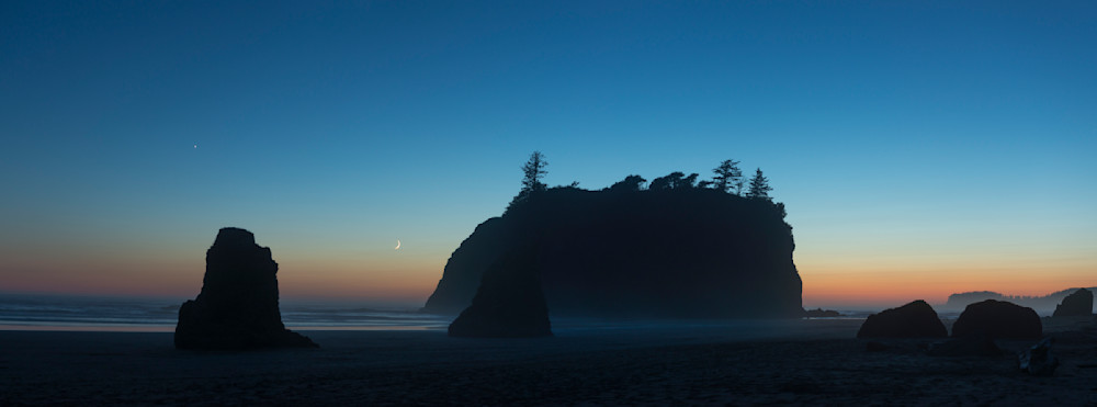 A fine art print of the moon nearing moonset, silhouetted sea stacks, dusk, Ruby Beach, Olympic National Park, Washington.by Greg Probst