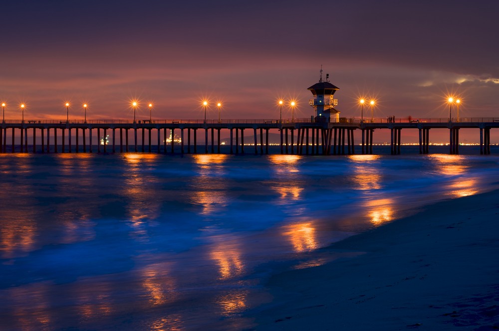 photo of the huntington beach pier with reflected lights on the water