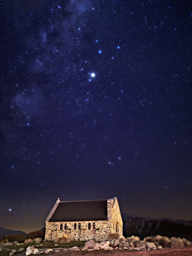 Beautiful photograph of a stone church under the stars