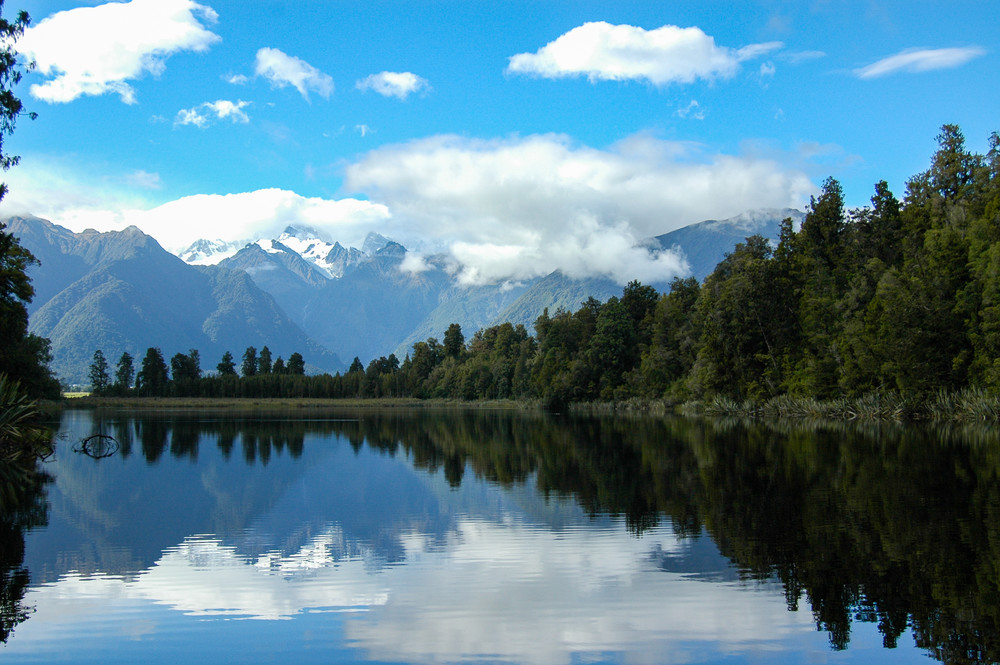 Stunning mountains and blue sky reflected in calm waters of New Zealand