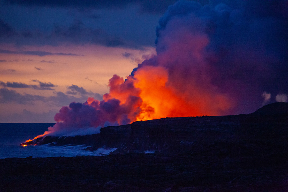 Glowing hot lava flows into the sea. Hawaii