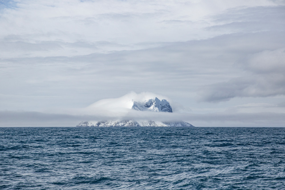 Ice and snow covered island in the distance, Gerlach Strait | Nicki Geigert, Photographer