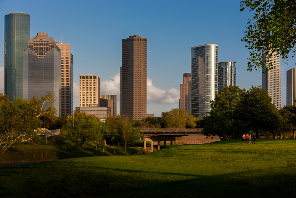 Runners along Allen Parkway in BRunners along Allen Parkway in Buffalo Bayou Park  with The Downtown Houston Skyline Behind Themuffalo Bayou Park  with The Downtown Houston Skylibe Behind Them