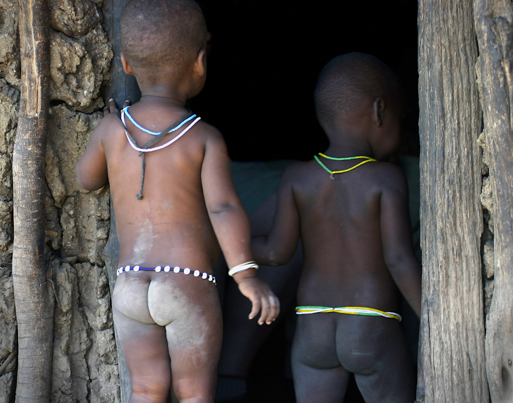 Datoga Datonga tribe Tanzania hut with two toddlers baby butts