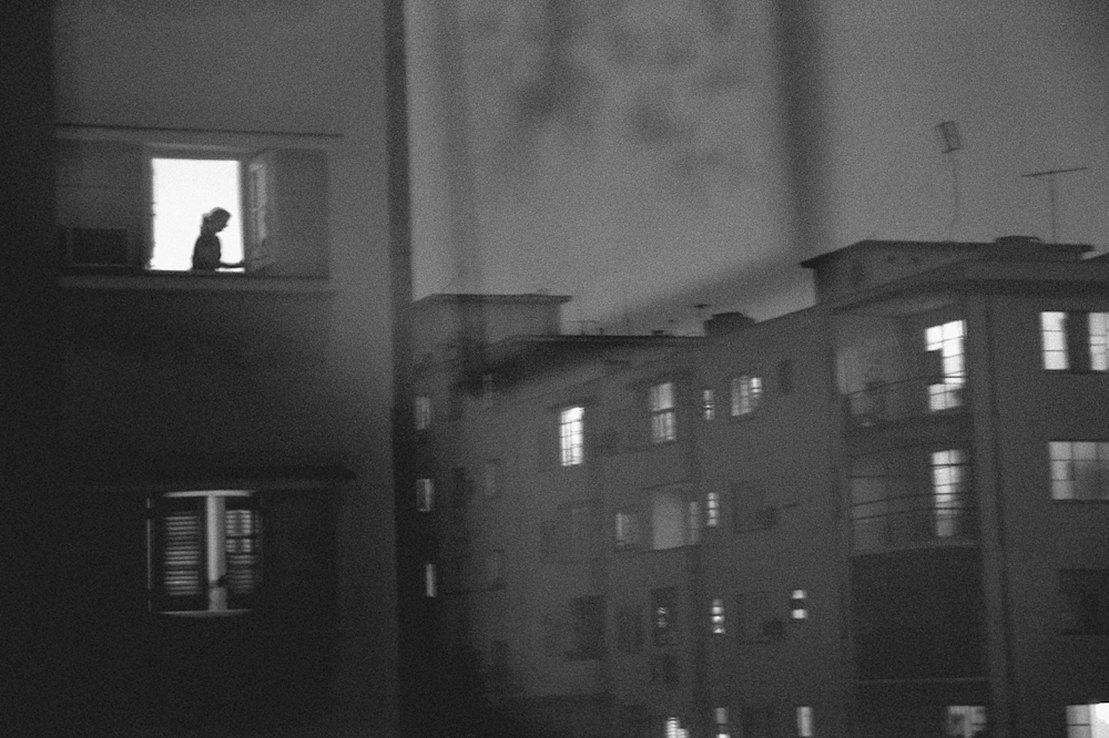 Woman in window at night in Havana, Cuba apartments