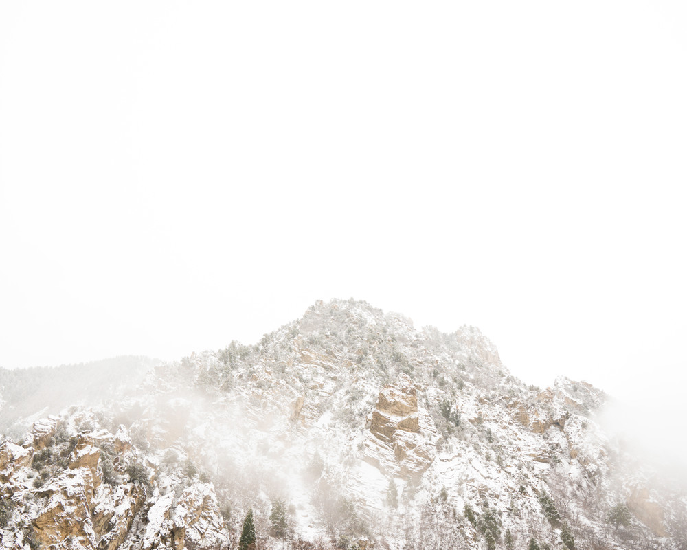 A fine art minimalist photograph of the top of a snowy mountain on a foggy afternoon by Mia DelCasino