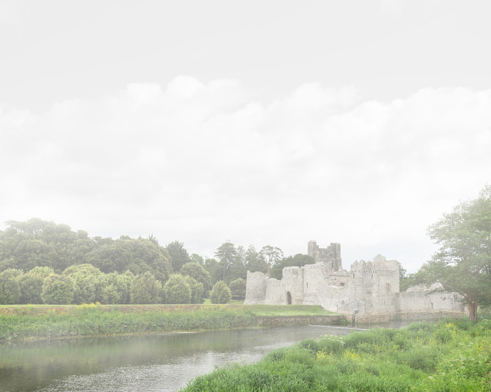 A contemporary photograph of a castle on the bank of a river on a foggy morning in Ireland by Mia DelCasino
