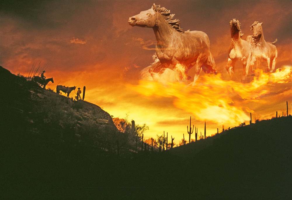 Composite image of a sunset in the western desert with fiery spectral ghost horses in the sky