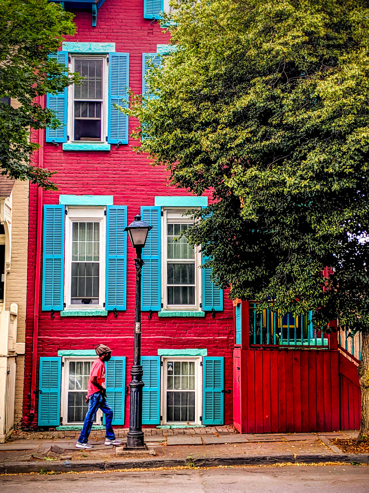 Man Walking By Red House