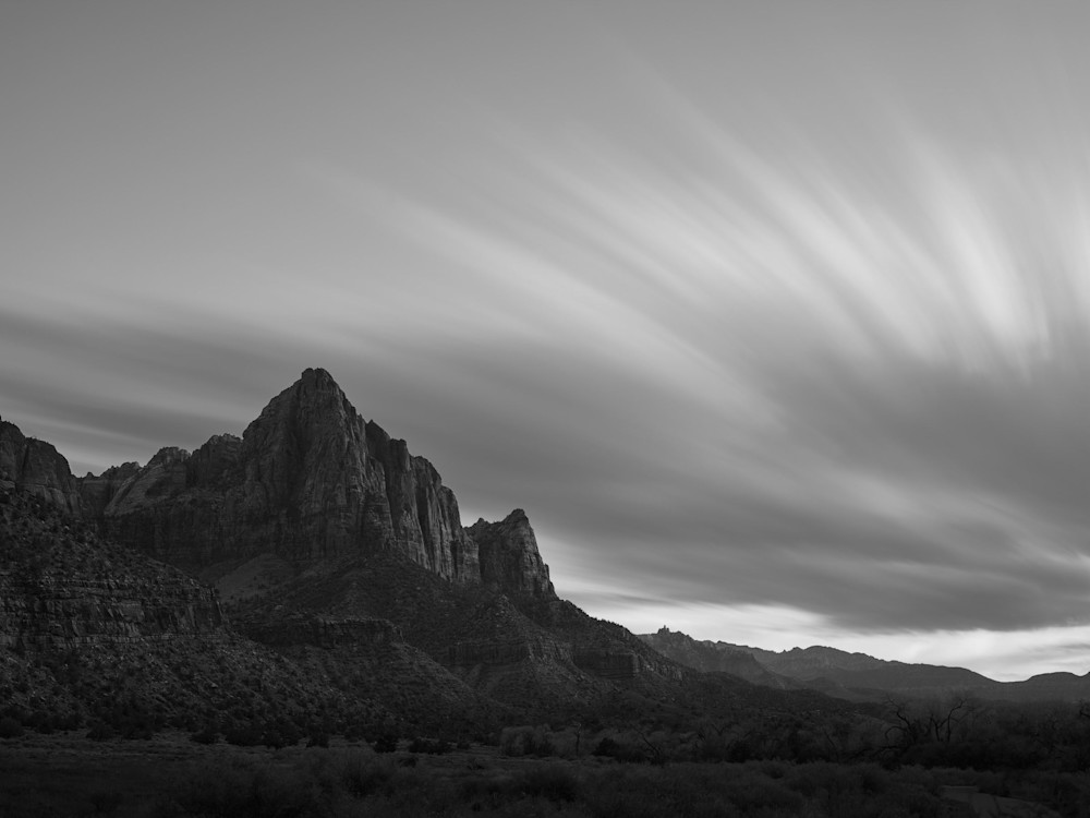 A dramatic, long exposure black and white landscape photograph of The Watchman of Zion National Park.