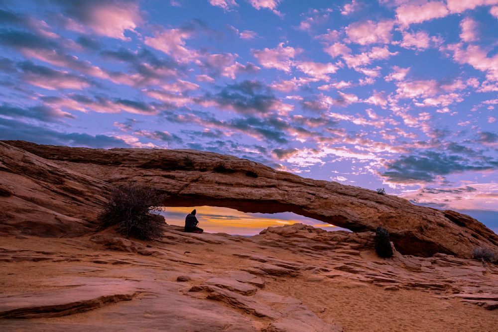 Lone Person Overlooking Mesa Arch at Sunrise