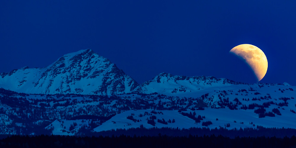 May 15, 2022 - Ashton, ID: The Super Flower Blood Moon lunar eclipse rising over the northern Teton Range.
