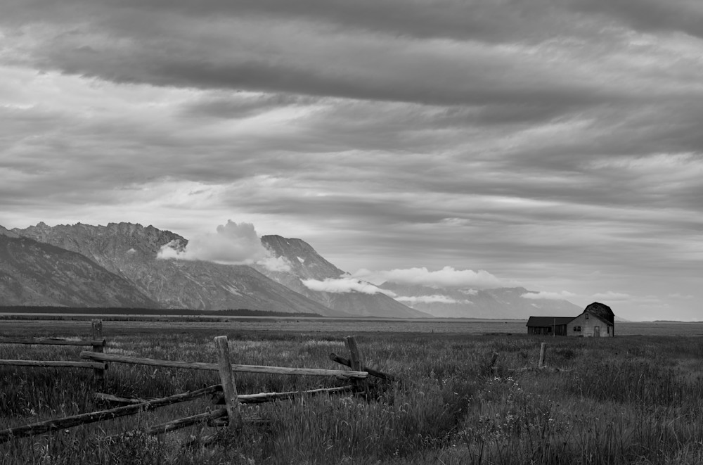 A moody black-and-white photograph of an abandoned early settler homesite in Jackson Hole, Wyoming. 