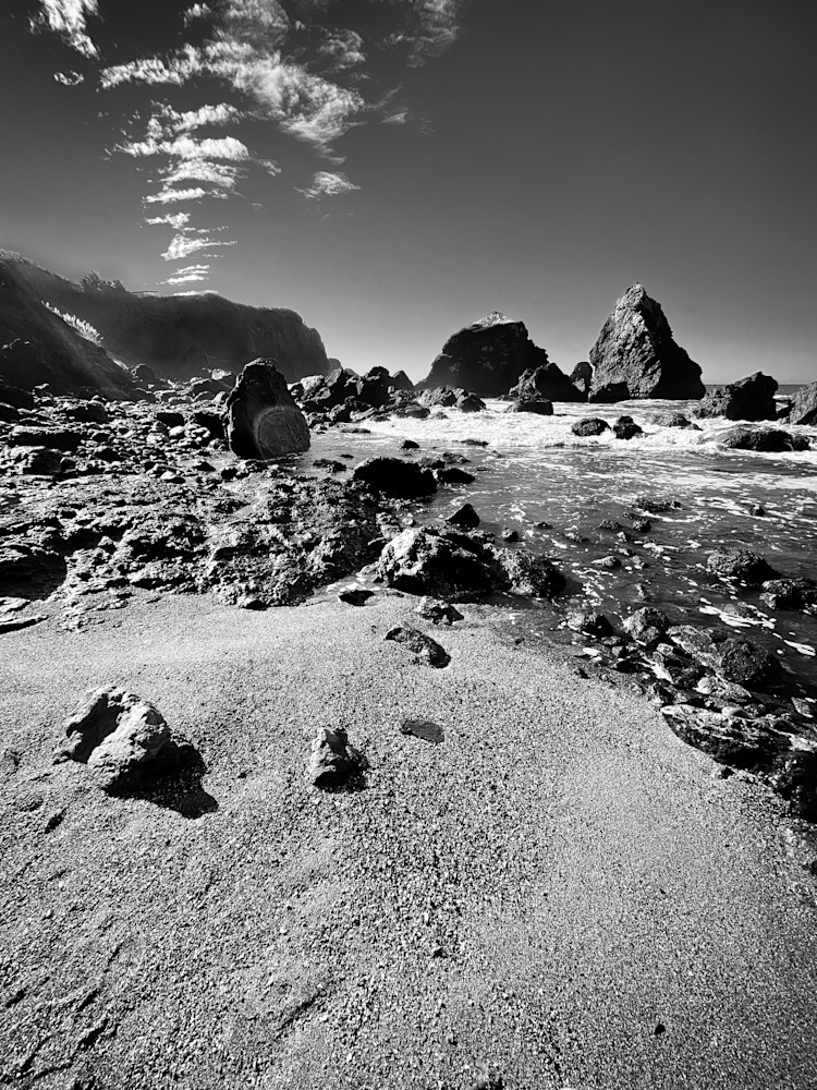 Pacific Ocean waves grind the Luffenholtz Beach boulders and cliffs into gravel in Humboldt County, California.