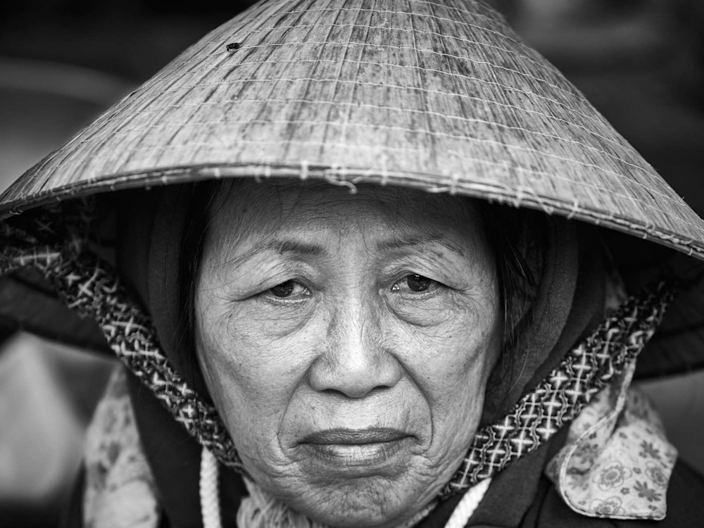 Authentic black and white  portrait of a Vietnamese woman wearing a traditional leaf hat.