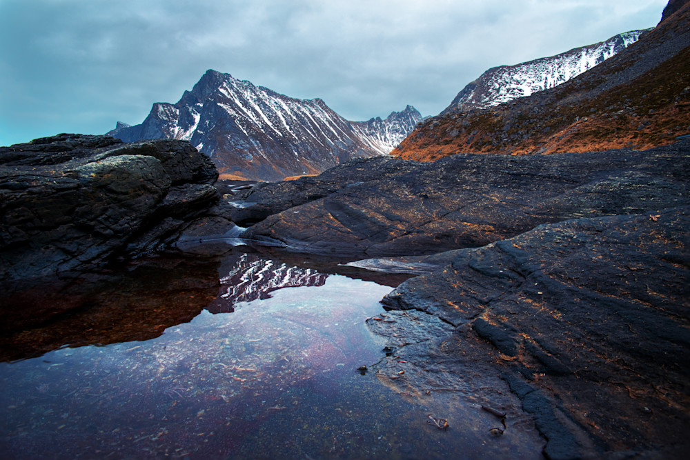The mountain of the nearby fjord reflects on Vikten Beach on the Lofoten Archipelago in Norway