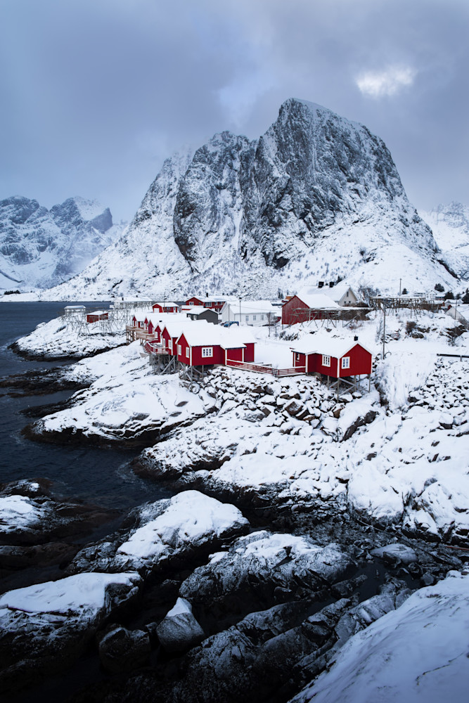 Red cabins with mountain in background along the shore in Reine / Homnøy, Lofoten, Norway
