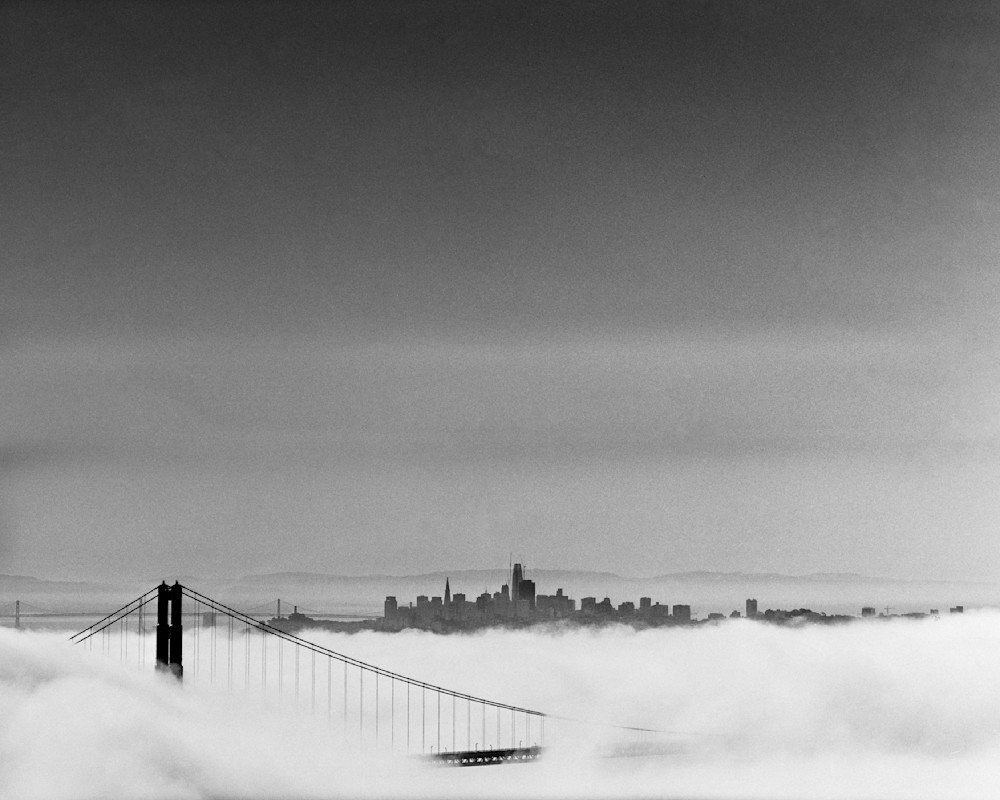 A black and white film photograph of the Golden Gate Bridge covered by clouds