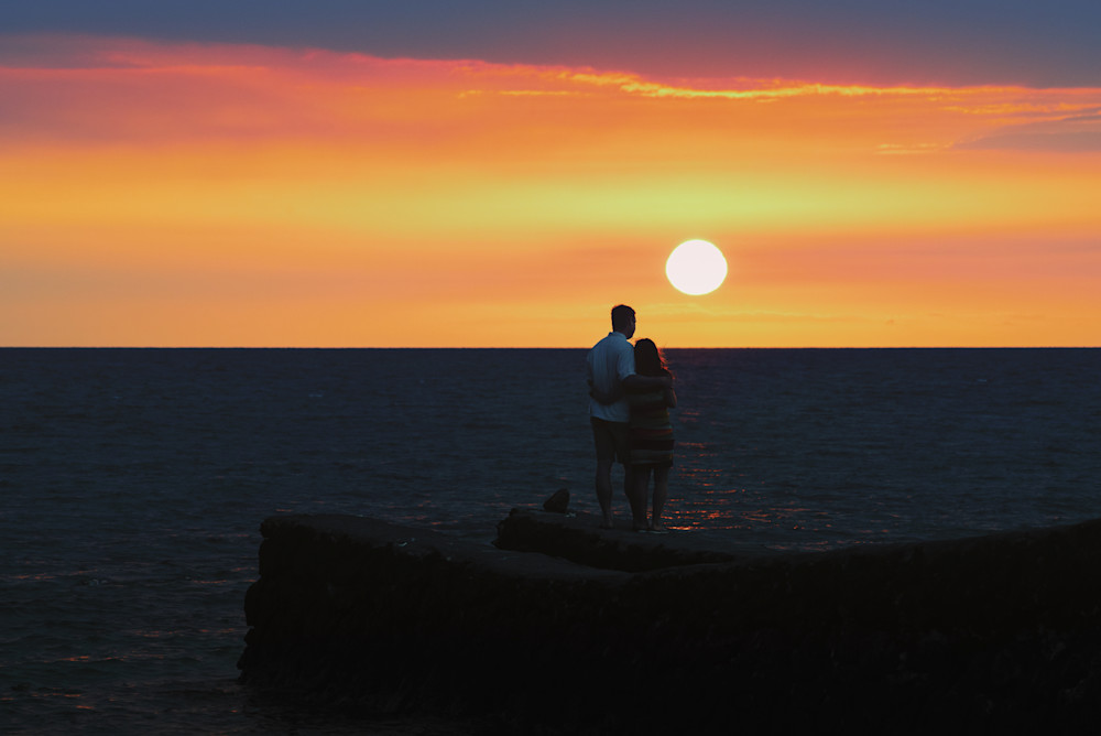 Couple watching sunset in Big Island, Hawaii