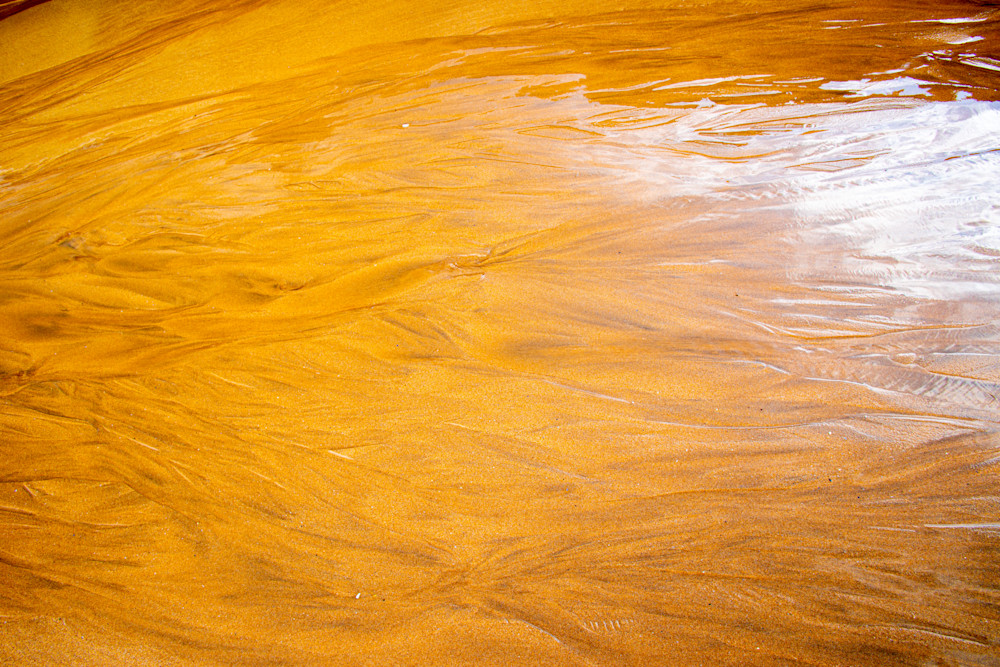 Abstract of orange beach sand and water taken in County Donegal, Republic of Ireland