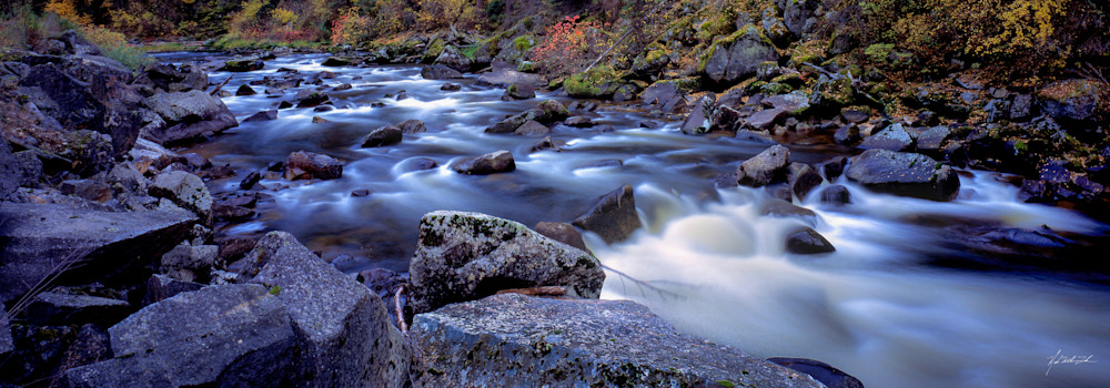 Water rushes past large boulders and fall foilage along the South Fork of the Clearwater River.