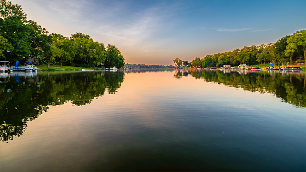Serene lake landscape at golden hour showcasing trees and reflections