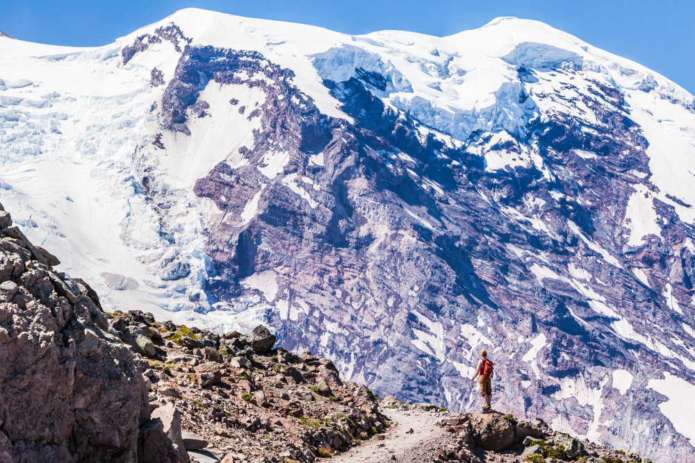 A woman hiking on First Burroughs Mountain below Mount Rainier, Washington, USA