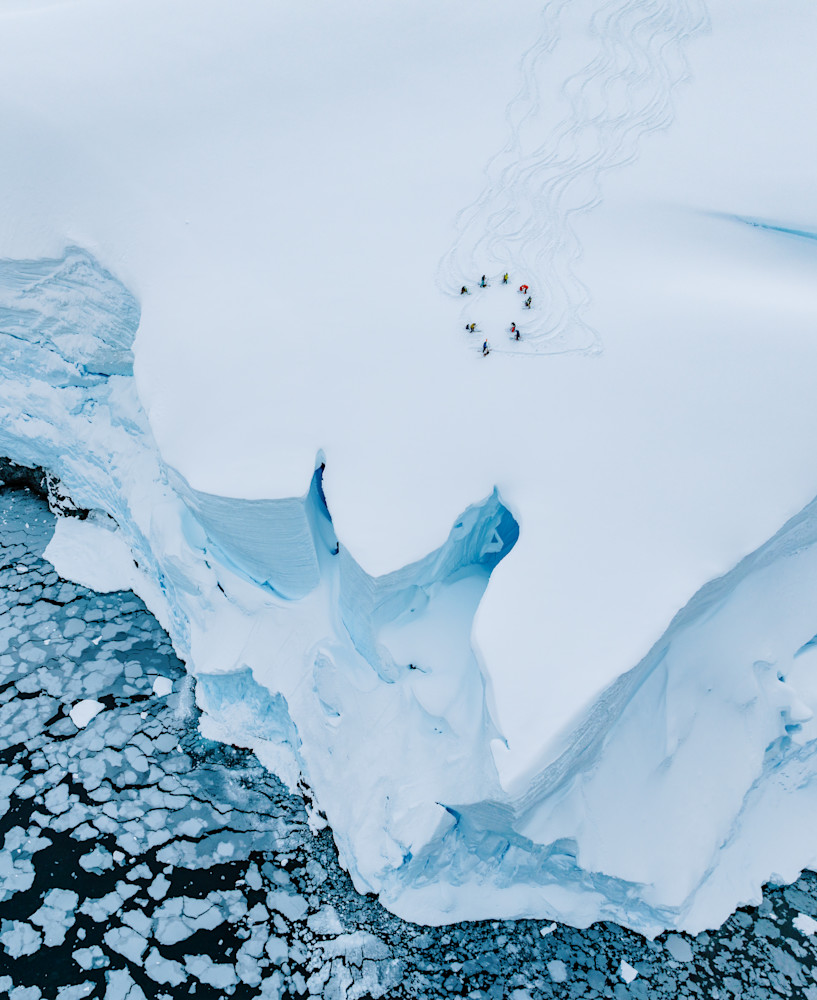 Aerial Skiers on Antarctic Glacier Above Sea Ice Cliff