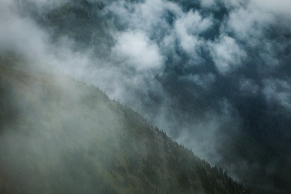 View of a mountain ridge from above looking through clouds.  North Cascades near Harts Pass, Washington, USA.