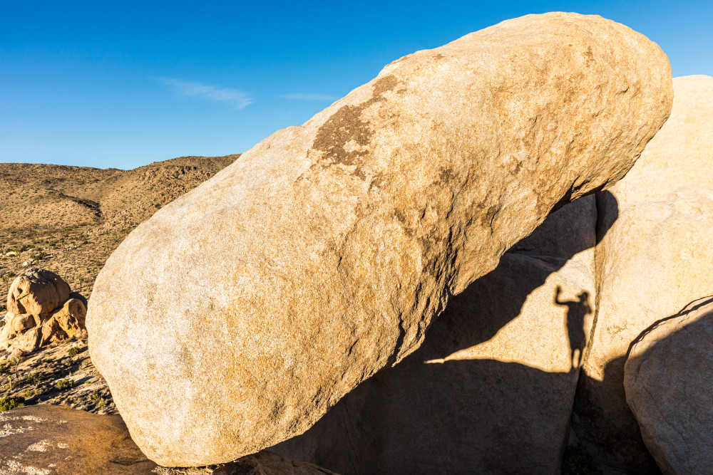 A photographers shadow selfie while climbing about rock formations in Joshua Tree National Park.