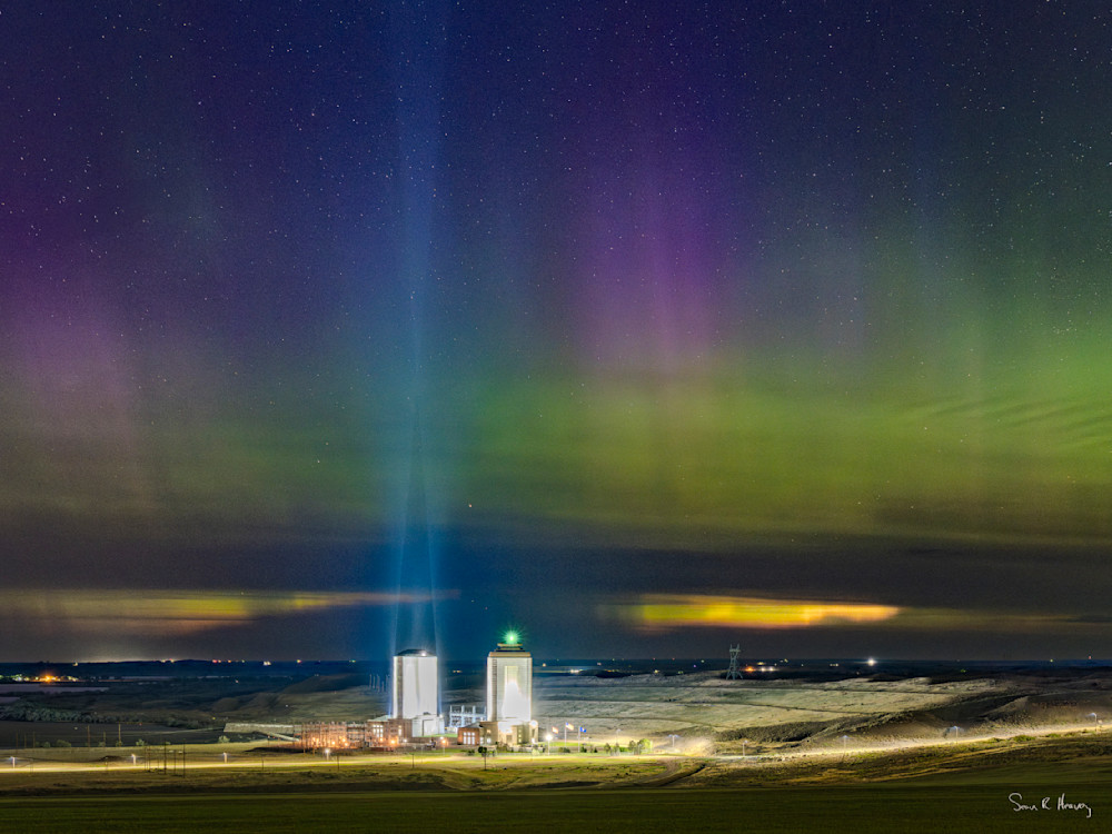 The powers house of Fort Peck Dam shine their spotlights to the heavens while the Nothern Lights dance above. | Fort Peck, Montana