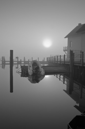 Sunrise over dinghy in morning fog plj7bv