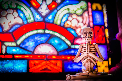 A yogi skeleton in front of one of the stained-glass windows in the mausoleum chapel