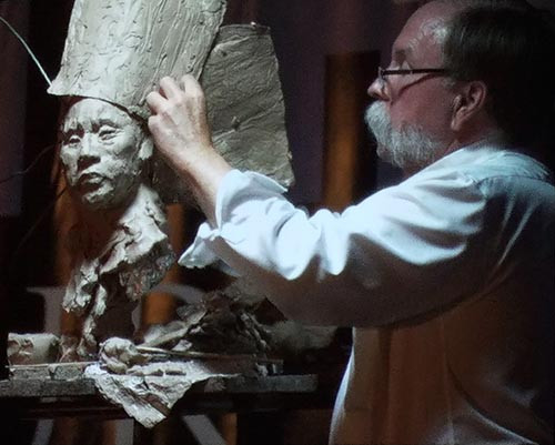 John Coleman transforming a sculpture of a girl into a Sioux warrior at the FACE convention in Miami.