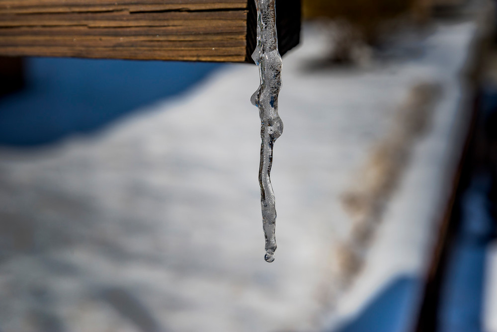 An woman-shaped icicle hanging from a mailbox