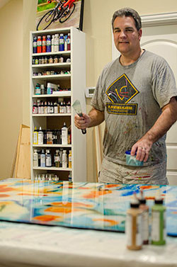 Sports artist Mark Trubisky painting in his studio.