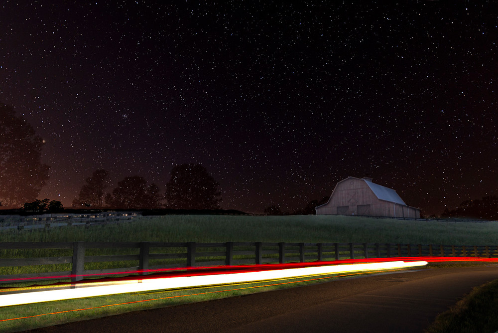 A barn in a field on a starry night