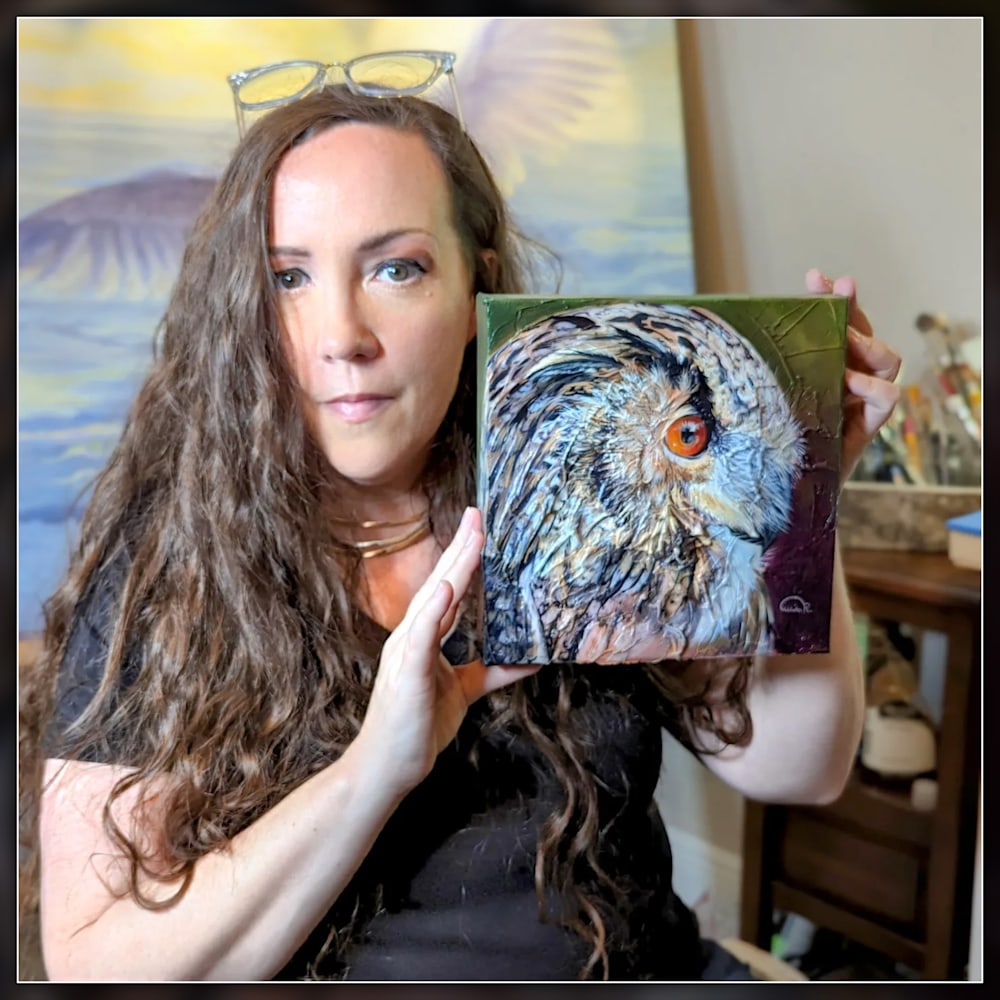 Artist Allison Richter holding her Eagle Owl painting Reflected Intensity