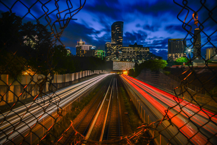 Photo of Atlanta taken at night through a hole in the fence over the 400