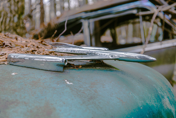 A hood ornament that looks a little like an airplane from an old car at Old Car City USA