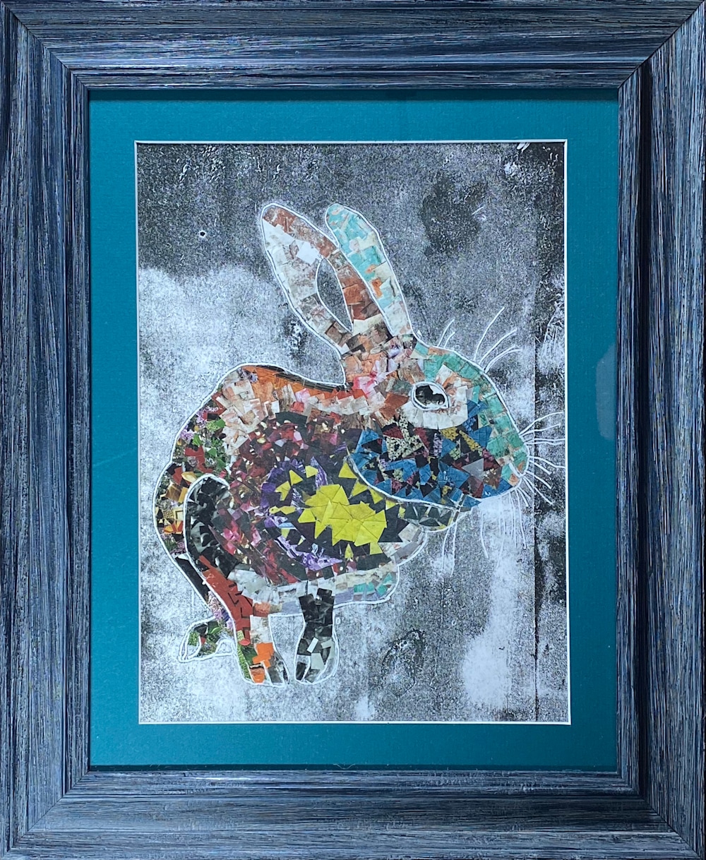 Collaged rainbow rabbit in dark teal frame with turquoise matting. 