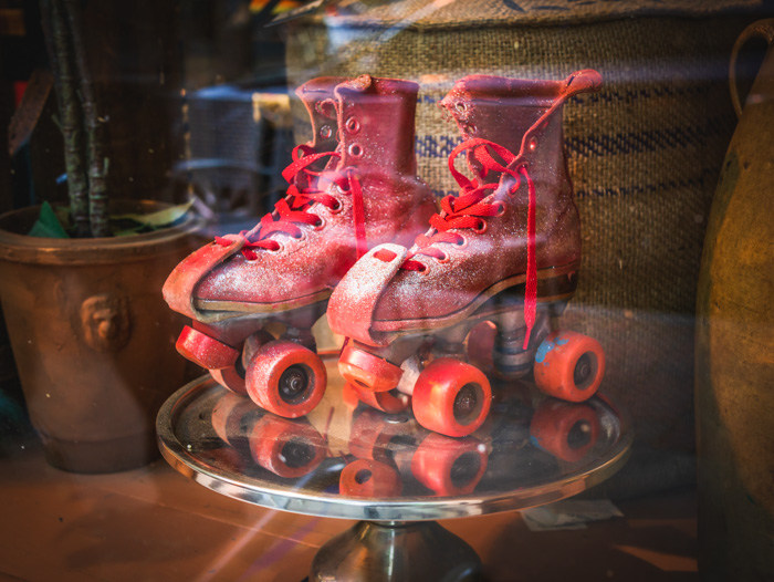 A pair of '70s roller skates in the window of a vintage store