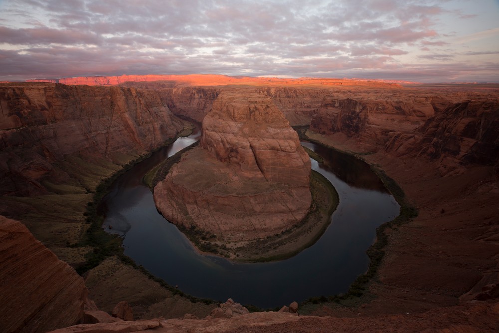 Unedited photograph of Horseshoe Bend as shadows fill Glen Canyon and clouds fill the sky.