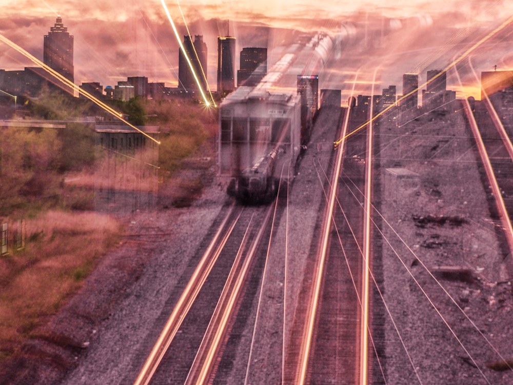An abstract photo of an oncoming train with the City of Atlanta in the background. There's lots of movement and light trails