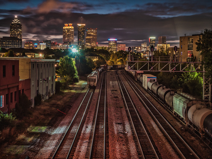 A long exposure early morning shot of the railroad tracks with the City of Atlanta in the background. It's still dark out and the lights of the city are still on.